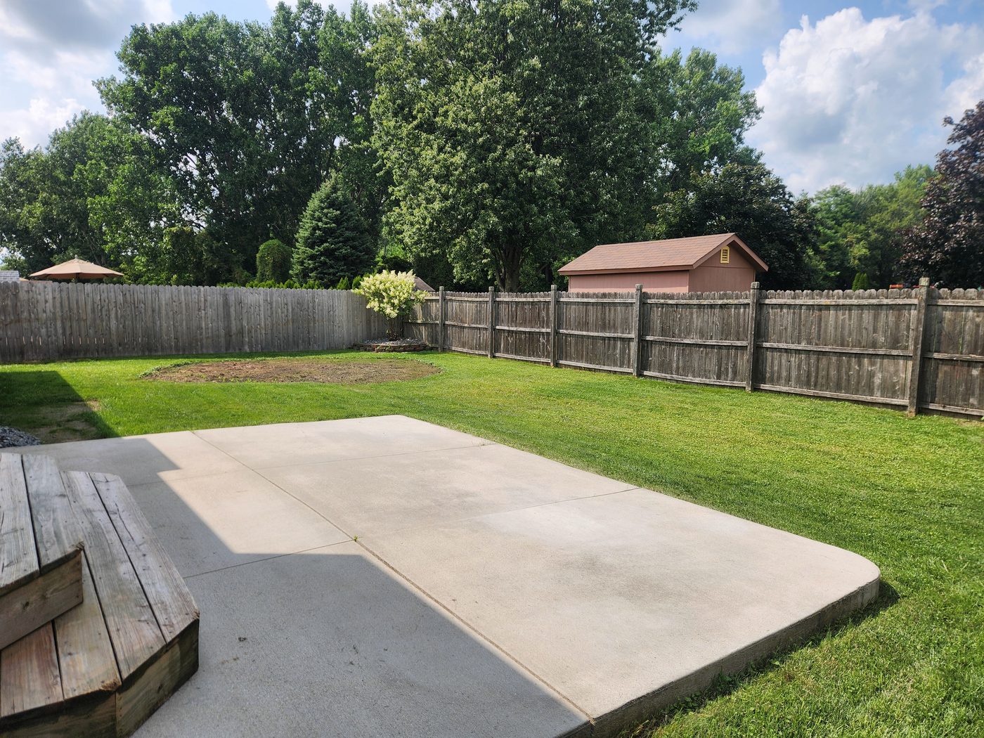 Fully fenced backyard with concrete patio
